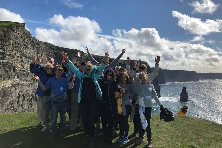 Small-group minibus beside Irish coastal cliffs on a 10-day Ireland vacation tour from Dublin