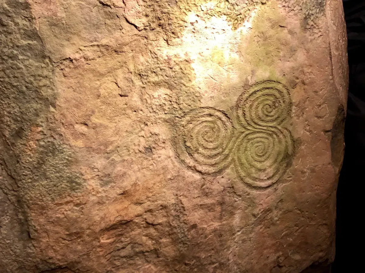 Triple spiral carving at Newgrange in the Boyne Valley, a day trip on many Ireland tour plans